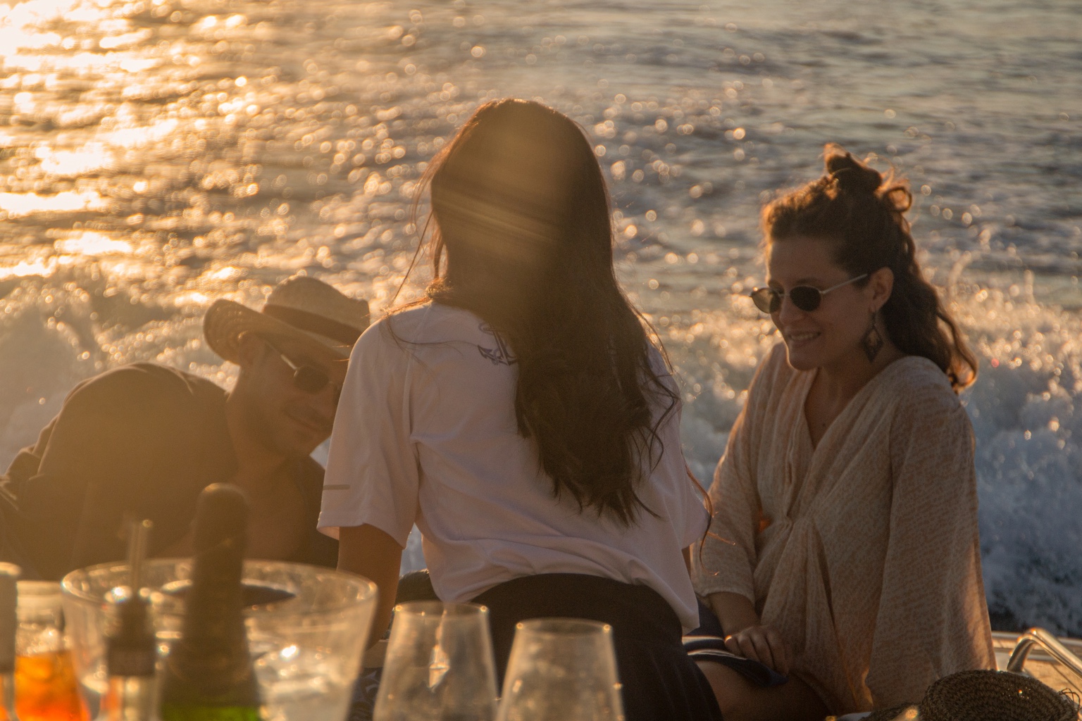 A couple holding hands on a boat in the sunset light